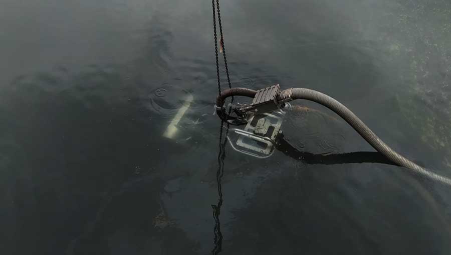 Robot subacqueo ROV durante operazione di ispezione e pulizia di una vasca industriale sommersa