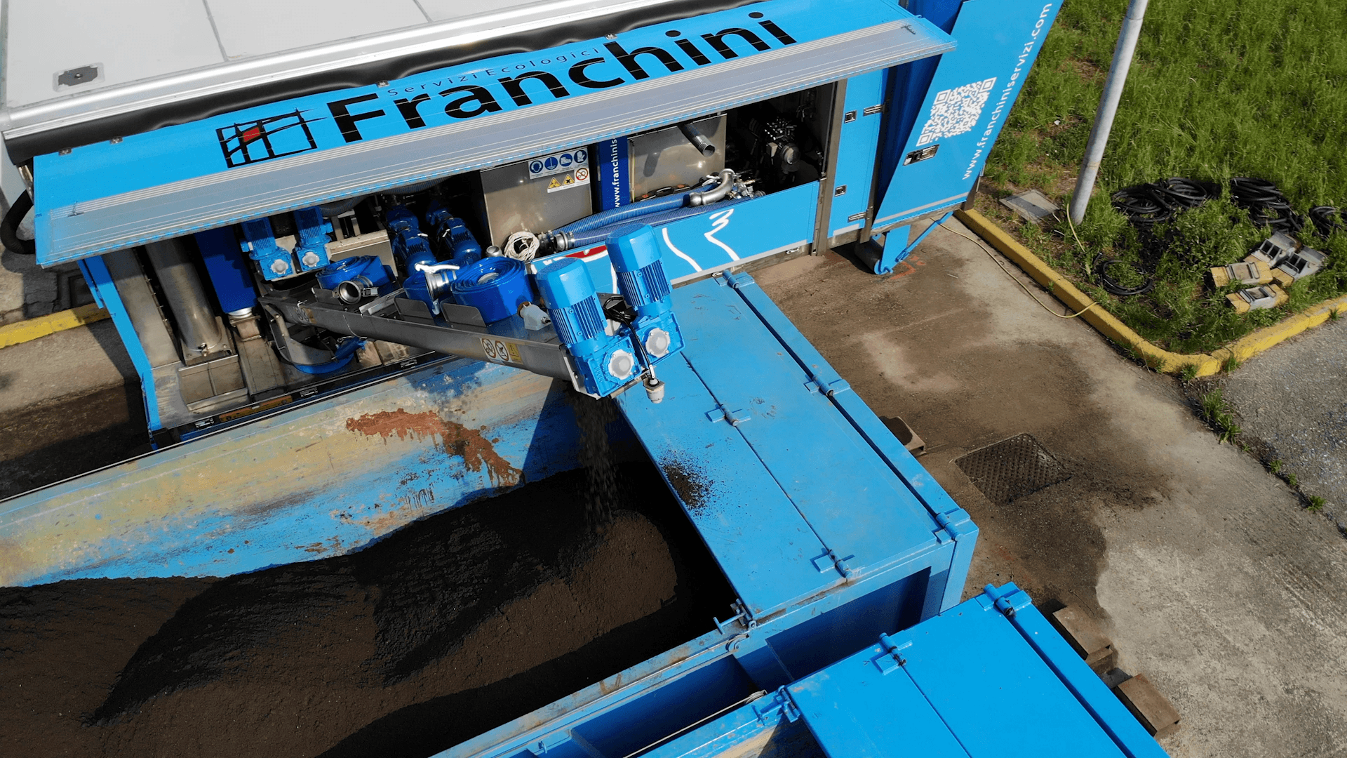 Alt Text: Centrifuga industriale per la disidratazione dei fanghi in funzione in impianto di trattamento